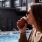Woman sitting by the pool drinking cider