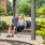 a couple sitting on a wooden swing-bench outdoors
