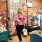 a woman smiling a sshe tries on clothes in a retail store