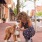 a woman petting a dog outdoors and in the nearby downtown environment
