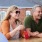 a couple laughing as they have mixed drinks with people